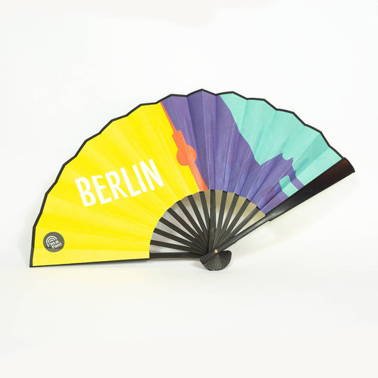 Foto des Fächers mit Design Berliner Wahrzeichen von I'm a Fan! mit Berlin Schriftzug, Fernsehturm und Brandenburger Tor, gelb und verschiedene Blautöne